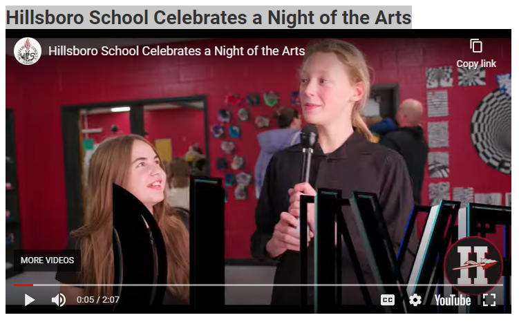  Two students talking into a microphone about night of the arts.