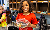  student holding a snake in a bowl