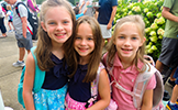  3 girls smiling with backpacks on