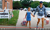  student and mom walking on sidewalk