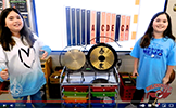  two girls smiling next to gongs