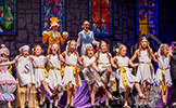  students on stage in costumes