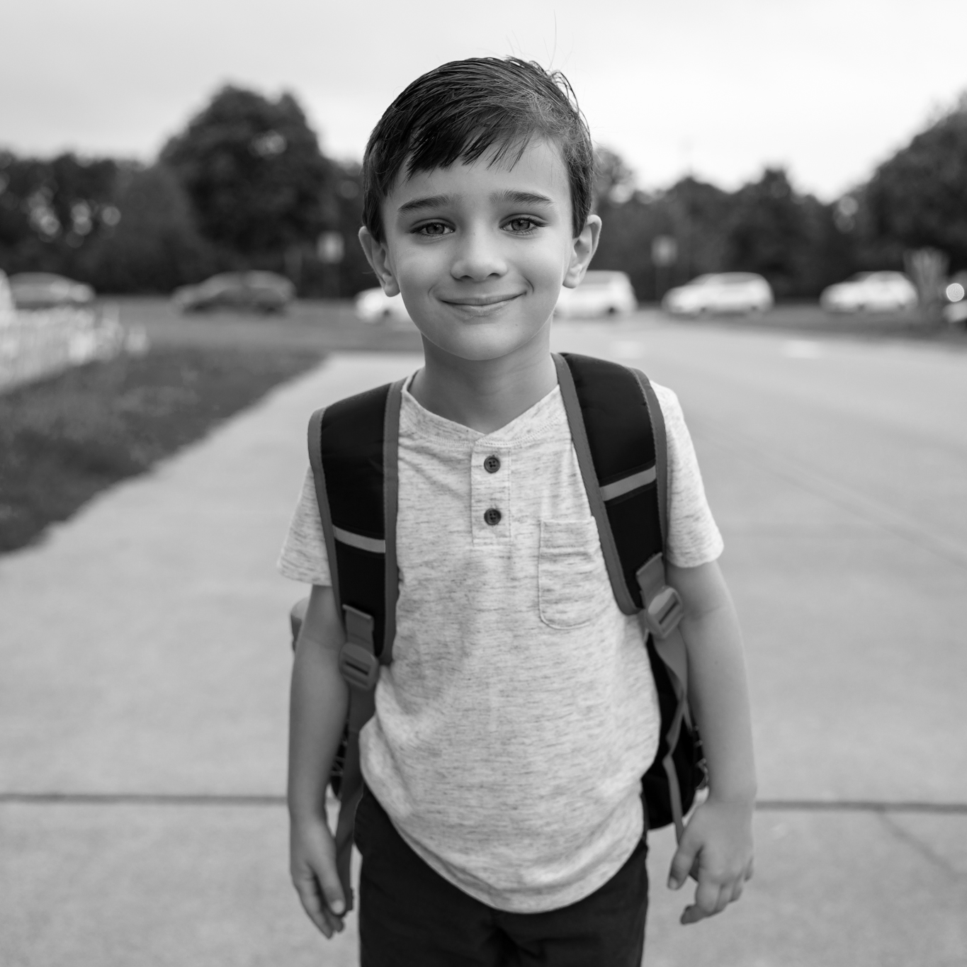 boy student walking to school along sidewalk