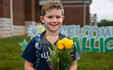 boy holding yellow flowers 