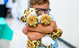  boy hugging a cheetah stuffed animal