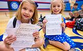 two girls with music sheets