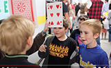  boy with a giant playing card 6 over his head