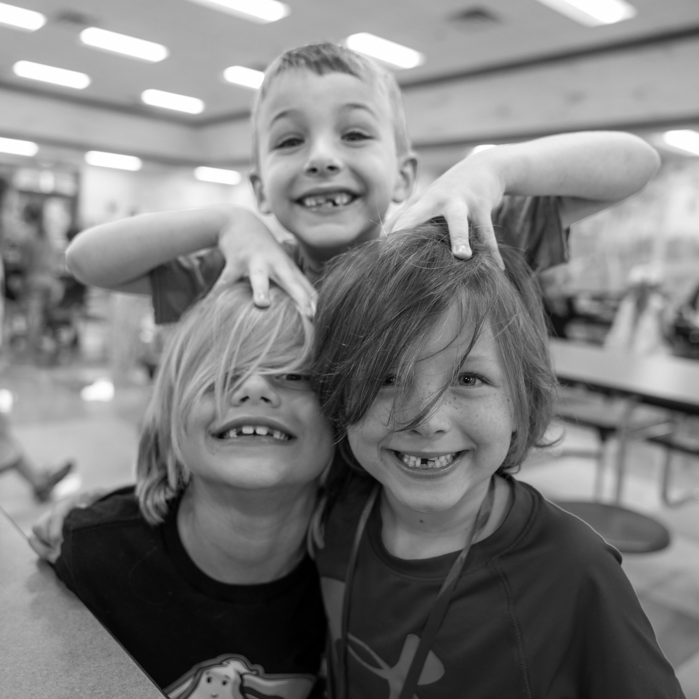 three boys smiling with hair in their faces