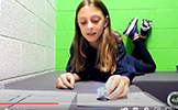 a girl laying on the floor showing her Ozobot 