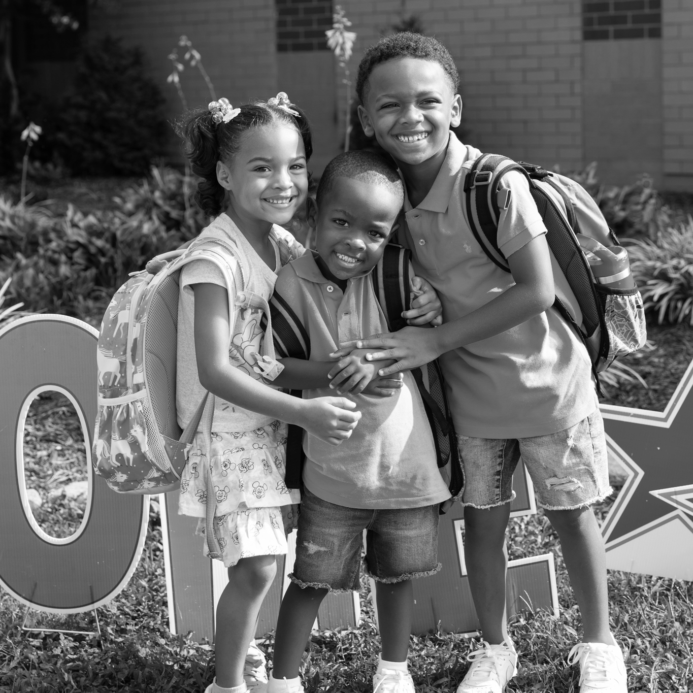 three kids in front of CES yard sign
