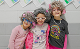 three girls in gray wigs and hair curlers