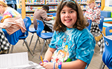  girl smiling sitting at table