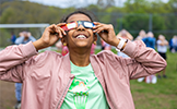  student looking up wearing eclipse glasses