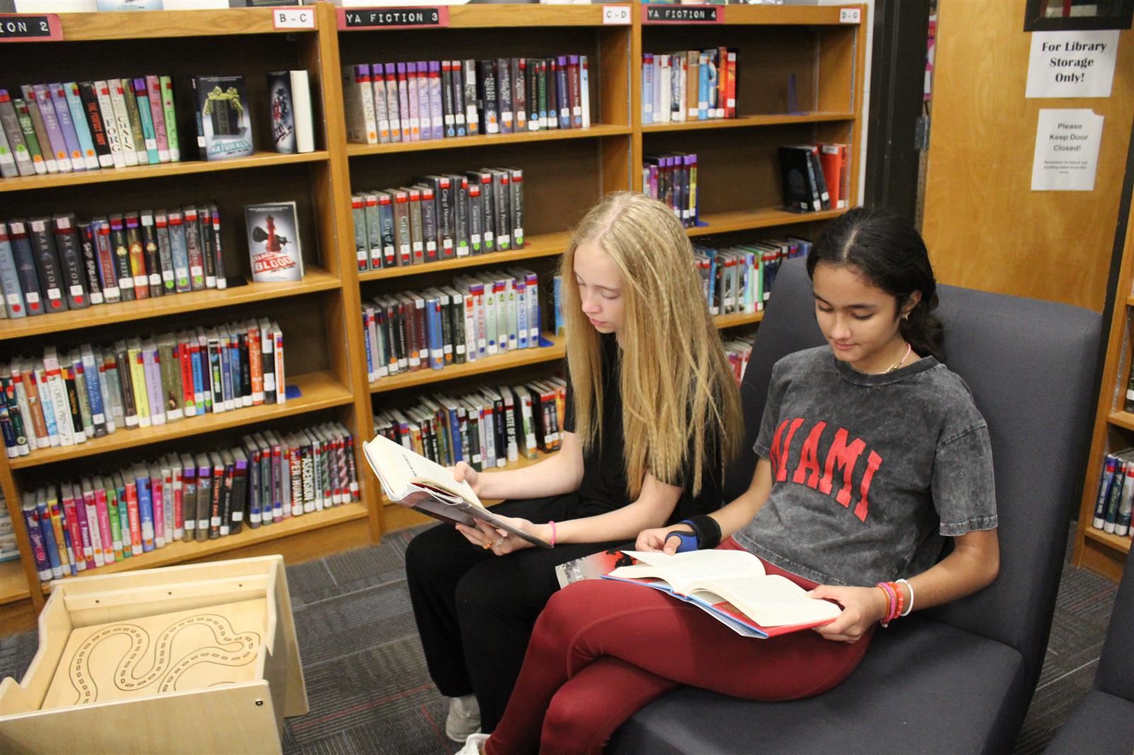 two girls reading on a couch