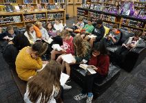  Students shown sitting and reading in the library media center