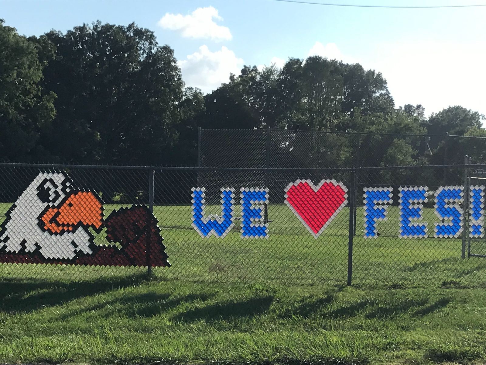 sign on fence with eagle that says we HEART FES