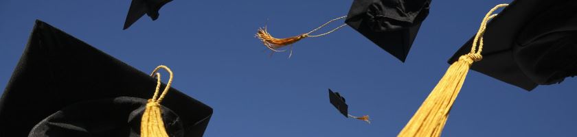 graduation caps thrown in air