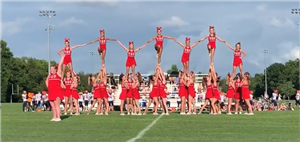 Warrior Football Cheerleaders stunting on the field during a game