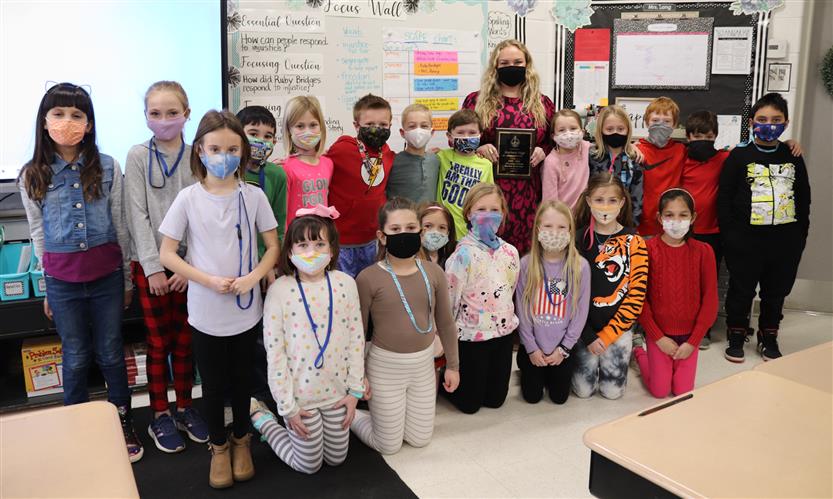 Teacher and students stand in group