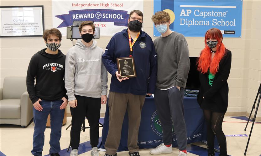 teacher and students stand in a group
