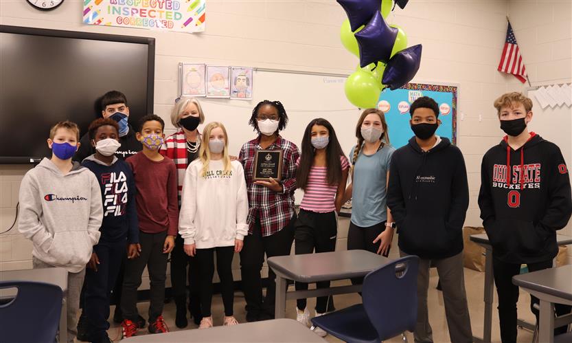 Teacher and students stand in a group